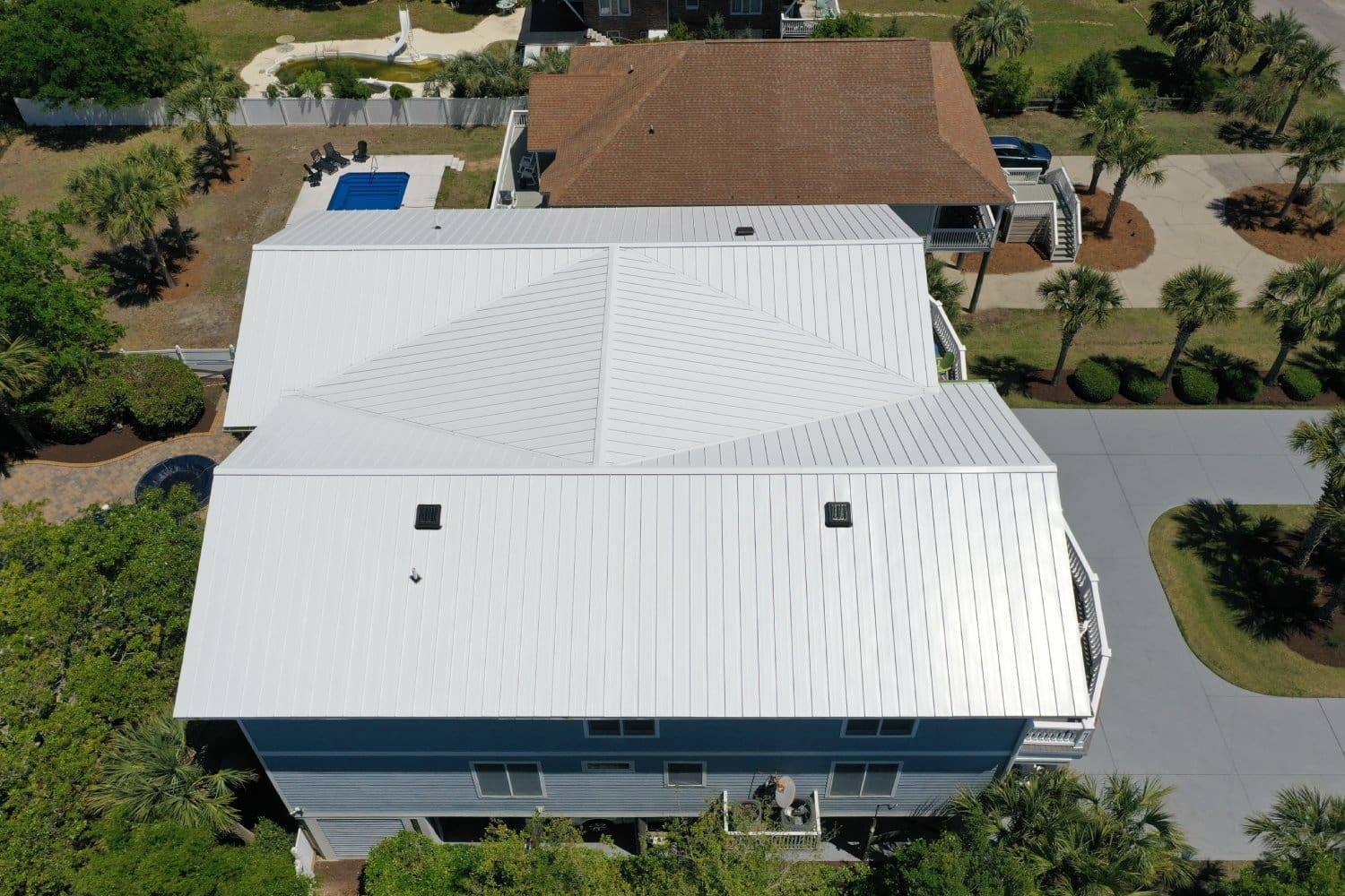 A white house with a roof that has been painted.